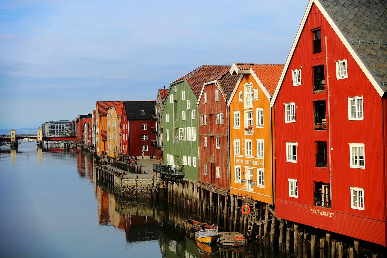 Fargerike bryggehus på påler langs Nidelva i Trondheim